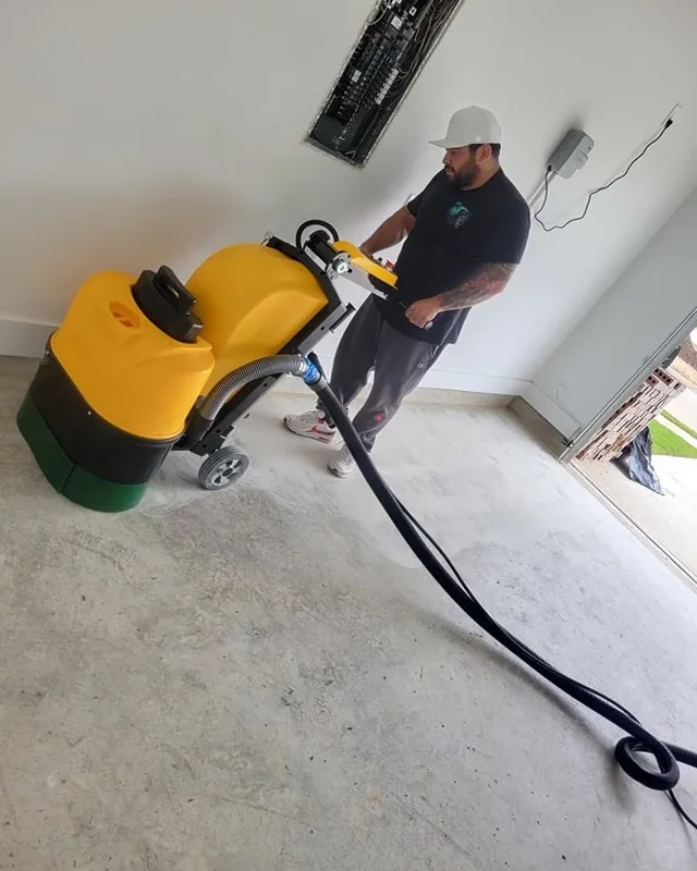 Victor Ramos running a grinder on a garage slab